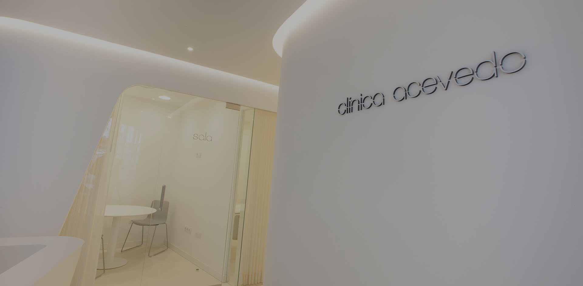 Entrada de Clínica Acevedo, con su logotipo en la pared curva de la recepción